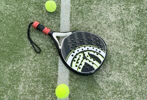Paddle tennis racket, ball and net on the grass photo