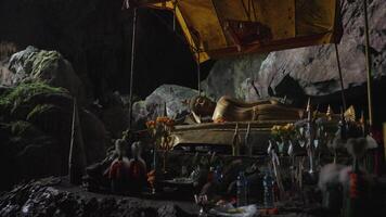 Vang Vieng, Laos - November 14, 2023 - Sacred cave of Tham Phu Kham - a stalactite and a stalagmite in the karst mountain with buddha temple inside video