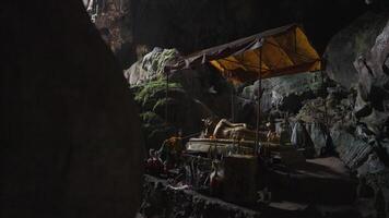 Vang Vieng, Laos - November 14, 2023 - Sacred cave of Tham Phu Kham - a stalactite and a stalagmite in the karst mountain with buddha temple inside video