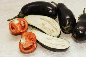 Eggplant and tomatoes on the table before cooking photo
