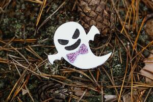 Toy ghost made of felt in the forest, Halloween decor photo