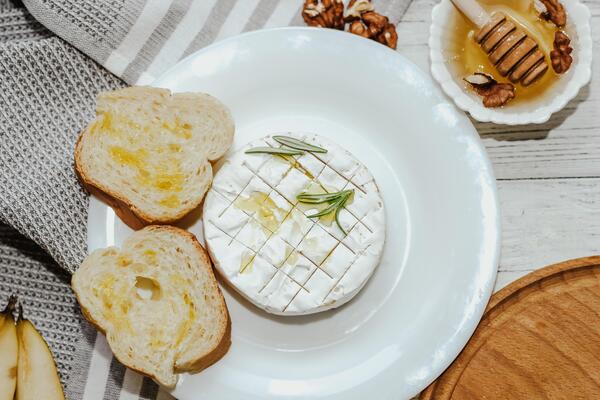 White baguette cut into pieces with olive oil and Camembert cheese on the table