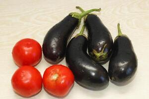 Eggplant and tomatoes on the table before cooking photo