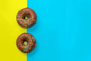 Round-shaped donuts with chocolate glaze and colored sprinkles photo