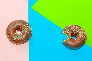 Round-shaped donuts with chocolate glaze and colored sprinkles photo