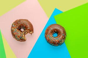 Round-shaped donuts with chocolate glaze and colored sprinkles photo