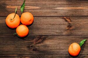 Tangerines on the background of a wooden brown table with boards photo