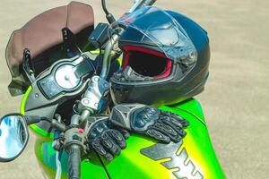 Black protective gloves for a motobiker with plastic inserts and a black helmet photo