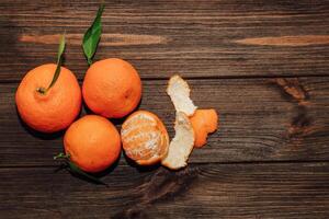 Tangerines on the background of a wooden brown table with boards photo