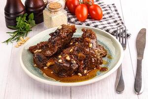 Prepared tasty beef ribs with sauce photo