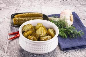 Sliced marinated cucumbers in the bowl photo