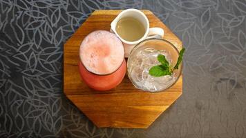 Flat lay of Refreshing Watermelon Juice with Sugar Syrup and Ice on Wooden Tray in Cozy Cafe photo