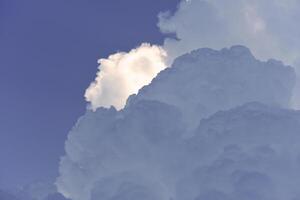 Blue-white cumulus clouds in the rays of the sun. Thunderstorm clouds. photo