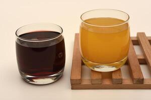 Juice in glass cups on a stand. Cherry and orange juice. photo