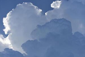Blue-white cumulus clouds in the rays of the sun. Thunderstorm clouds. photo