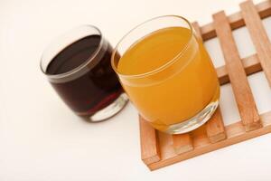 Juice in glass cups on a stand. Cherry and orange juice. photo