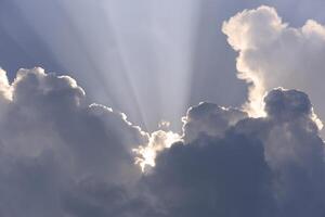 Blue-white cumulus clouds in the rays of the sun. Thunderstorm clouds. photo