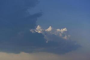 Blue-white cumulus clouds in the rays of the sun. Thunderstorm clouds. photo