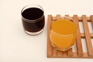 Juice in glass cups on a stand. Cherry and orange juice. photo