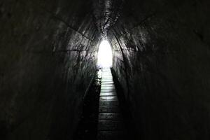 Light at the end of the tunnel. Narrow passage and exit. photo
