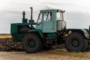 Old tractor plows close-up photo