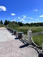 a bridge with benches and a pond in the background photo