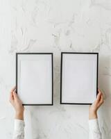 Hands Placing Blank Photo Frames on Wall for Mockup