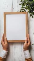 Hands Placing Blank Photo Frames on Wall for Mockup