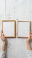 Hands Placing Blank Photo Frames on Wall for Mockup