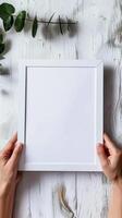 Hands Placing Blank Photo Frames on Wall for Mockup