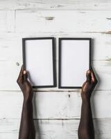 Hands Placing Blank Photo Frames on Wall for Mockup