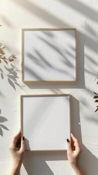 Hands Placing Blank Photo Frames on Wall for Mockup