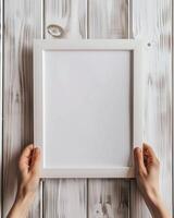 Hands Placing Blank Photo Frames on Wall for Mockup