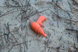 Squirt gun laying on the beach photo