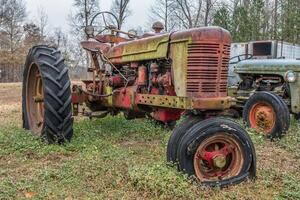 Farm tractor abandoned in field photo
