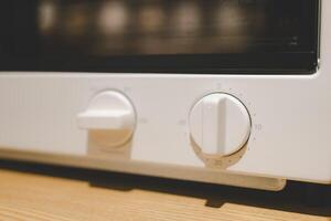 Close up Circular button to control the microwave oven. Microwave oven circular timer for one hour, analogue white. photo