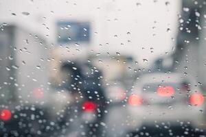 Rain drops on car window and lights. the bokeh image made with traffic and electric lights through the window of car on a rainy day. photo