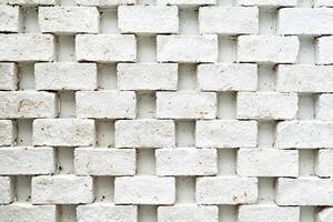 A white brick wall. The bricks are arranged in a regular pattern, with each row offset from the one above and below it. photo