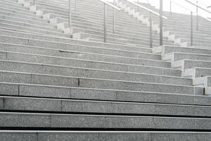 Abstract stairs in black and white, abstract steps, stairs in the city. A modern staircase with wide, smooth concrete steps and sleek stainless steel handrails. photo
