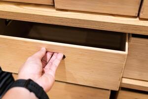Hand opening the wooden drawer. Use hand pull open drawer wooden in cabinet. photo
