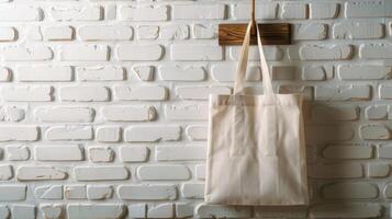 A blank tote bag hanging on a wooden hook against a white brick wall, perfect for custom design displays photo