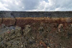 The curb erosion from storms. To indicate the layers of soil and rock. photo