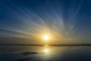 Sunrise above the lake with line of cloud and motion on water photo