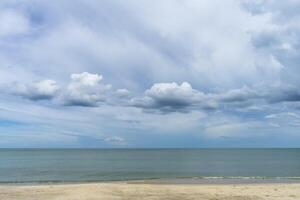 Nobody on the beach with blue sky and clouds in rain season. photo