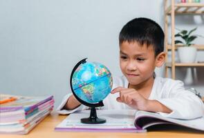 Kid Education, Asian boy looking at globe find the location of countries in the world, Concept for research global warming, global network, SEO search engine, Save the Earth, Ecology. photo