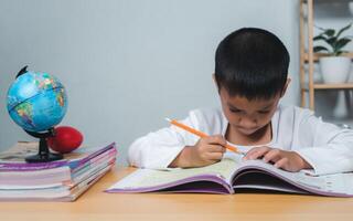 Education concept, Sad tired frustrated boy sitting at the table with many books, Bored and tired boy doing homework on desk in his room, Learning difficulties. photo