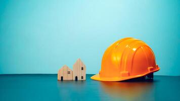 Hard hat for construction site workers and for engineers or workers, Standard safety helmet head protection, Wooden house model with hard hat with copy space, Engineering construction concept. photo