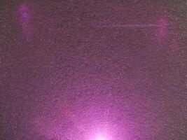 Pink light reflections on a plastic sheet in the dark for an abstract background. photo