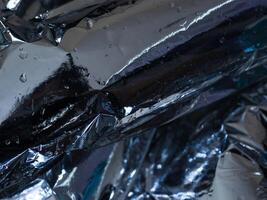 Silver plastic texture in the dark for a mysterious abstract background. photo