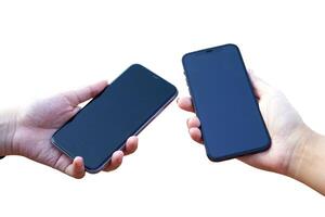 Isolated hands holding two cell phones with black screens held close together on a white background. photo